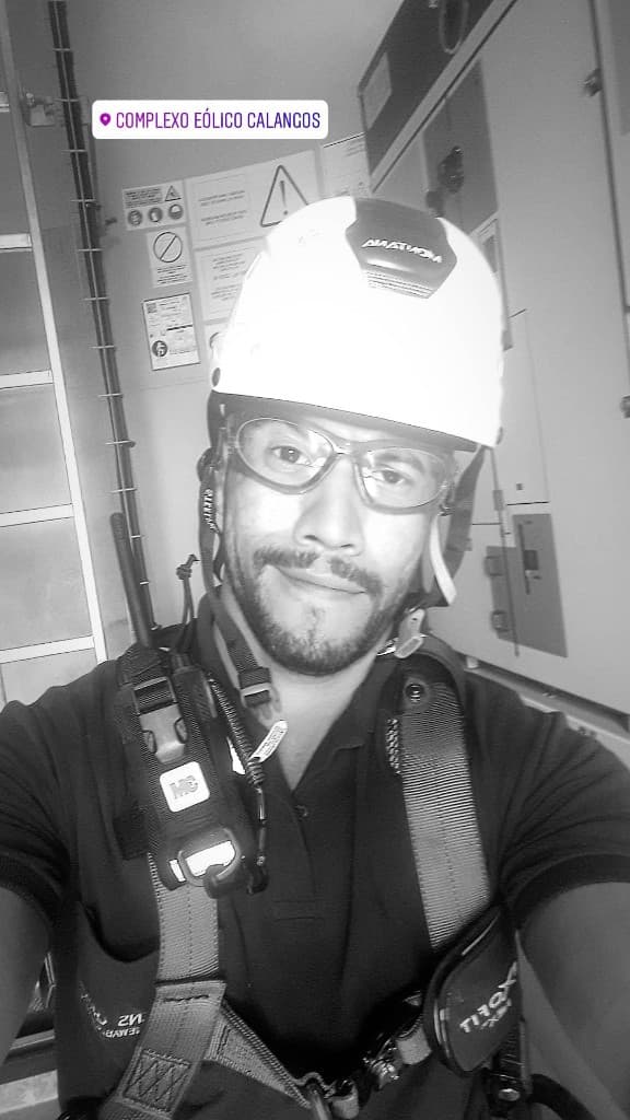 Vanderson Machado no Complexo Eólico Calangos, com capacete e equipamentos de segurança.